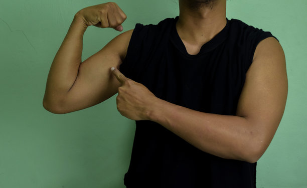 我很强壮。自信的成功年轻人的肖像，露出二头肌图片下载