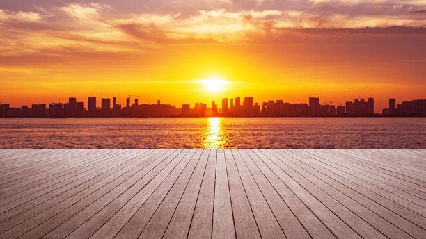 夕阳下空荡荡的木板路和现代城市天际线图片下载