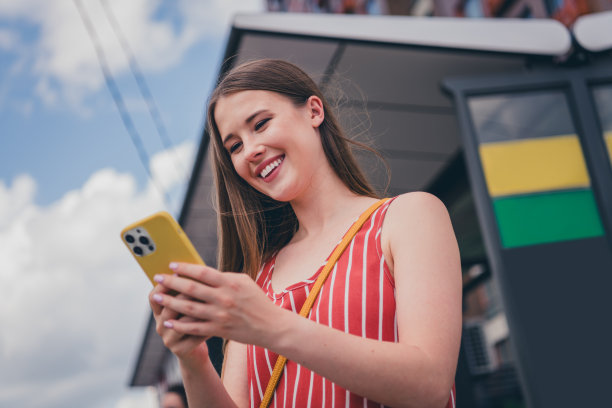 照片中可爱漂亮的女孩穿着时尚的衣服，手持设备阅读夏天后的户外天气图片下载
