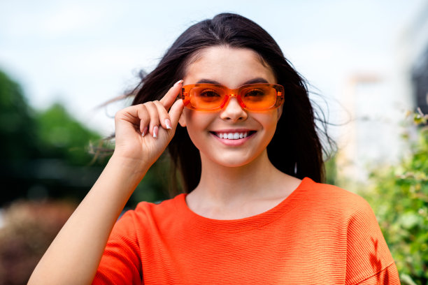 照片漂亮的青少年好心情的女孩太阳镜阳光明媚的天气度假穿红色的衣服走在城市城市公园图片下载