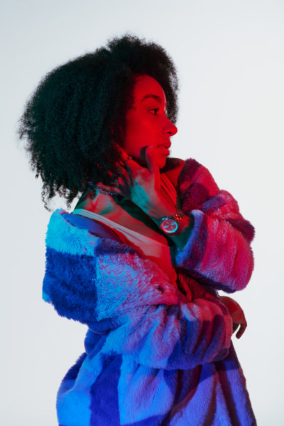 年轻女子穿着充满活力的时尚服装，在明亮的背景下艺术地摆姿势图片下载