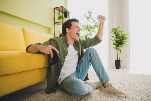 一个穿着时髦衣服的快乐男人坐在地板上度假的照片图片下载