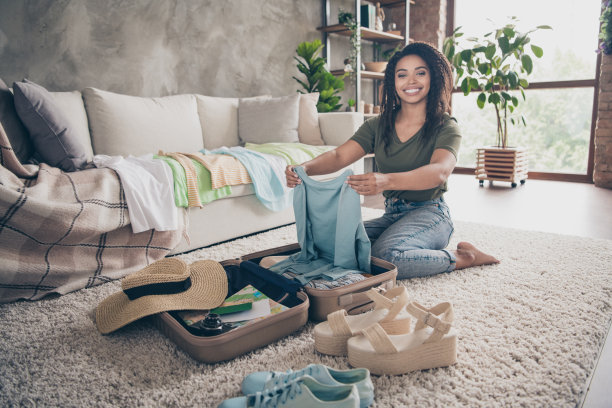 照片积极的好心情的女人穿着绿色的t恤包装衣服夏天旅行室内房子公寓房间图片下载