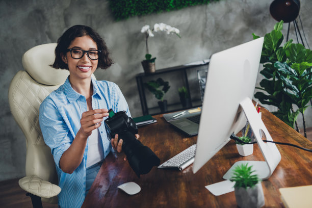 年轻女子的照片专业摄影师相机存储卡电脑阁楼室内办公室工作室室内图片下载