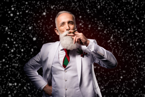 照片成熟的男人快乐积极的微笑享受烟雪茄优雅修饰孤立的深色背景图片下载