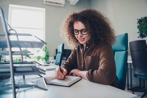 可爱的漂亮的迷人的成功的女人写每周计划工作现代代理办公室室内的照片图片下载