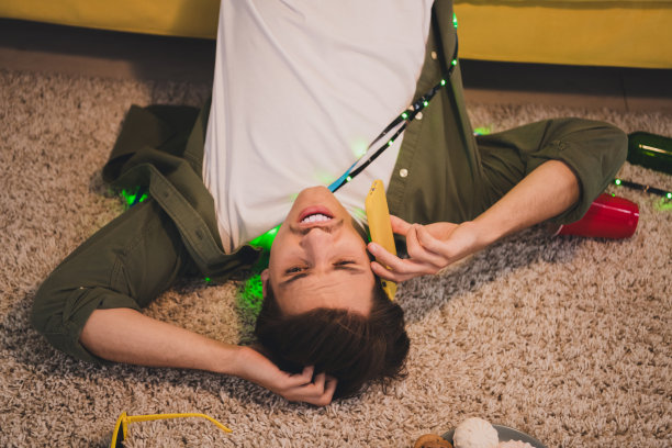 有趣的年轻宅男在派对庆祝周末后躺在房间里的照片图片下载