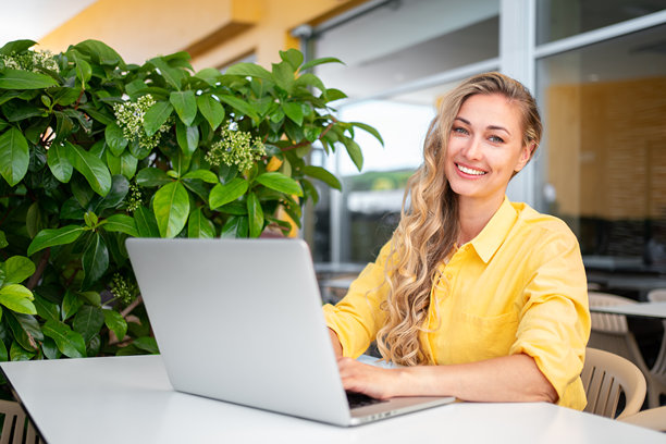 快乐的女性开发者在户外餐厅用笔记本电脑工作图片下载