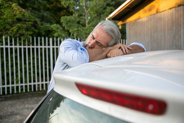 疲惫的老人在室外的车顶上休息图片下载