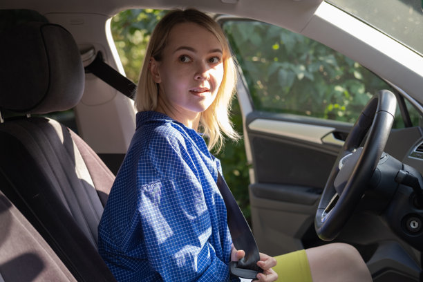 道路安全概念——漂亮的年轻女司机在车上系好安全带。图片下载