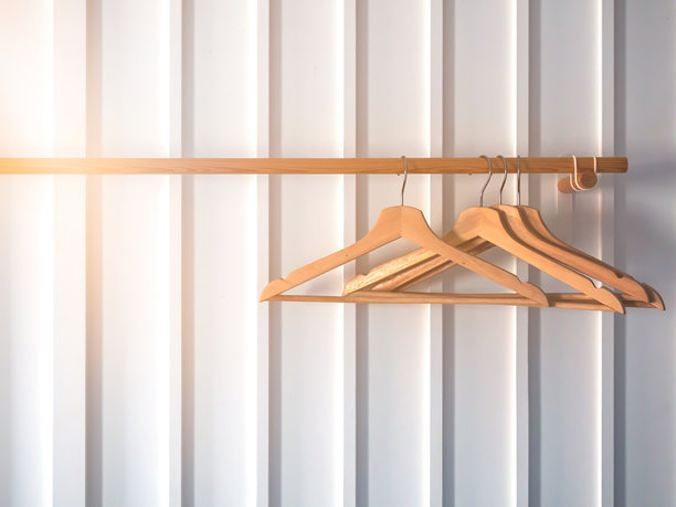 木质衣架，适用于白色条纹墙上的木质衣架。图片下载