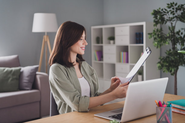 开朗迷人的人的照片坐椅子无线上网本桌子阅读剪贴板列表现代工作场所室内图片下载