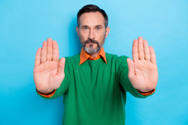 照片中严肃自信的商人灰胡子露出双手手掌不停地卖酒人有毒液体隔离在蓝色的背景图片下载
