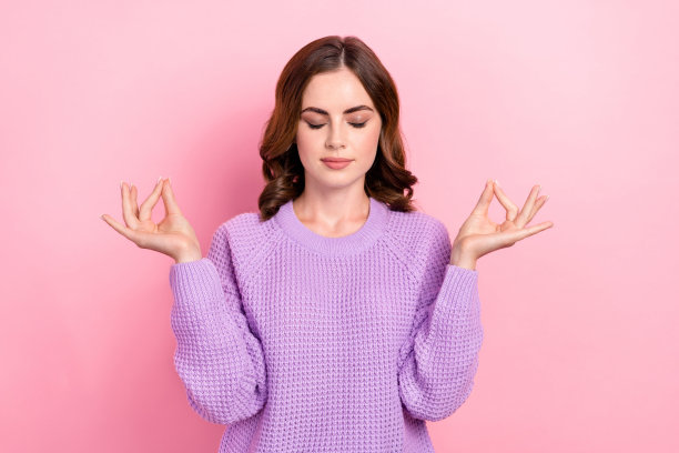 照片中可爱可爱的女士闭着眼睛穿着时尚的衣服避免压力抑郁手臂瑜伽符号孤立在粉红色的背景图片下载