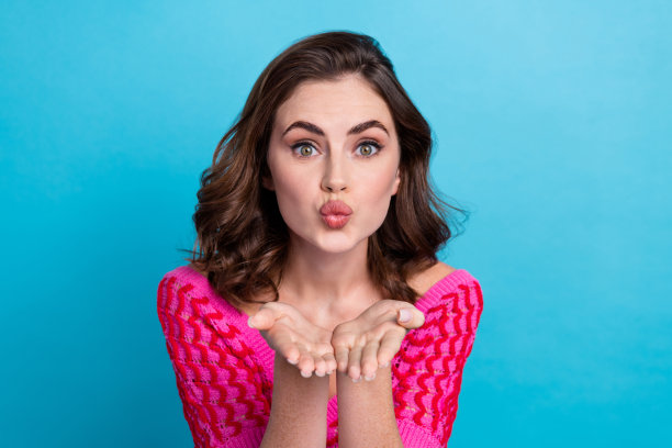 有趣的特写照片积极的棕色头发的女士噘嘴送空气吻你可爱的人穿粉红色时髦的顶部孤立的蓝色背景图片下载