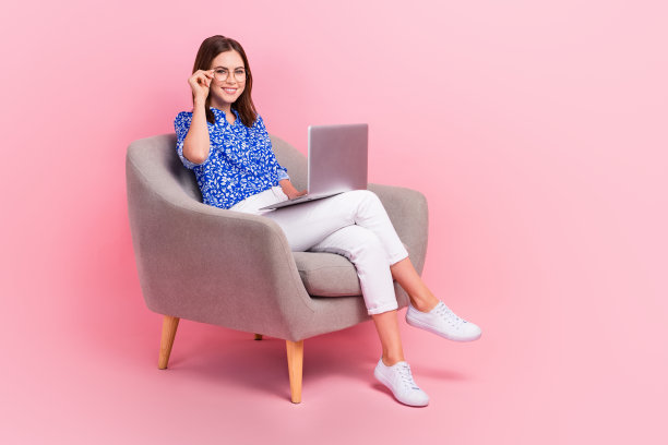 漂亮甜美的女人穿着蓝色衬衫的全身照片工作现代小工具空的空间孤立的粉红色背景图片下载