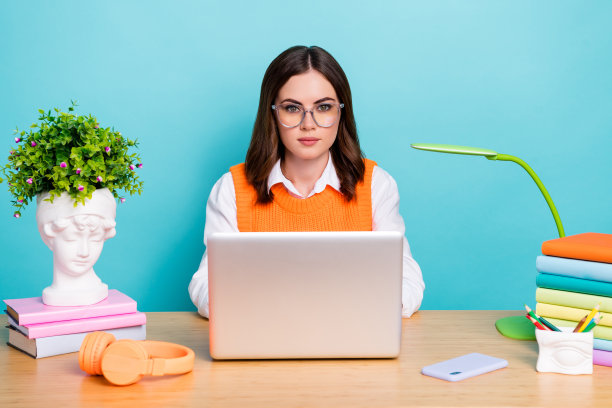 照片华丽可爱聪明的女士穿着时髦的衣服使用上网本在线课程测试考试孤立的青色背景图片下载