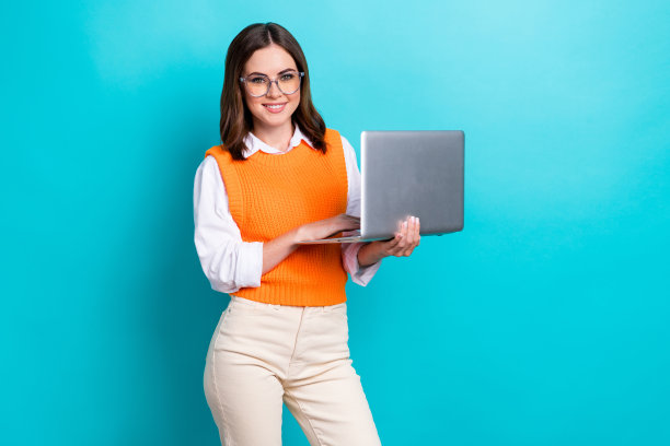 开朗满意的黑发女孩穿着校服的照片在线教育老师拿着上网本孤立在海蓝宝石的背景图片下载