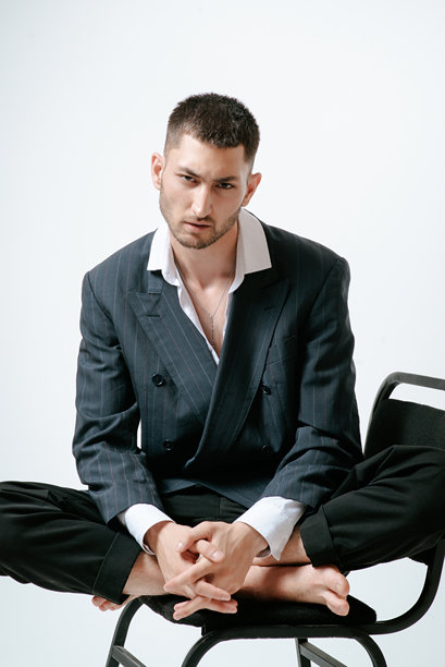 帅哥，时尚模特光脚坐在椅子上图片下载