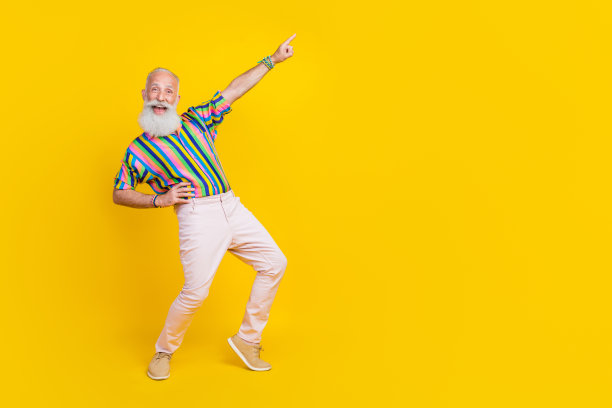 全身照片兴奋的酷男人穿彩色衬衫有乐趣显示手指空白空间孤立的黄色背景图片下载