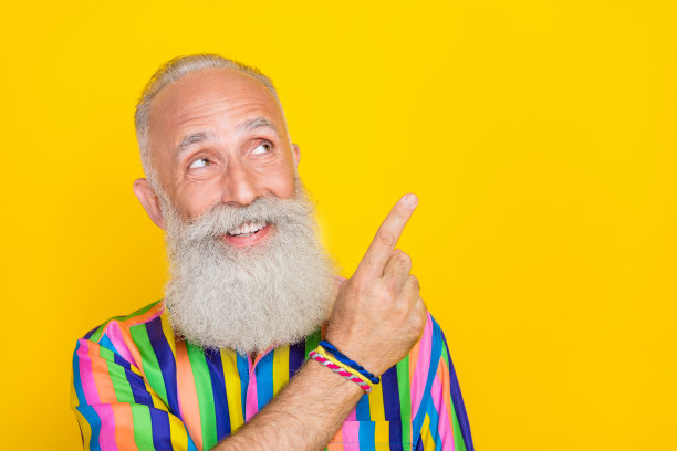 照片上的梦幻积极的男人穿着五颜六色的衬衫，看起来手指空白，孤立的黄色背景图片下载