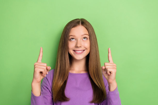 照片正面可爱的女士穿着时尚的紫色衣服呈现反馈新闻空白空间孤立的绿色背景图片下载