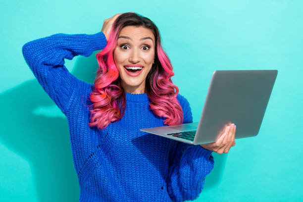 印象深刻的明亮女孩的照片卷发穿着蓝色毛衣拿笔记本电脑的手掌在头部孤立的充满活力的蓝绿色背景图片下载