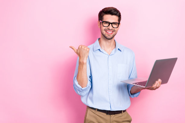 照片正面成功的男子用户演示空白空间建议购买现代设备上网本孤立在粉红色的背景图片下载