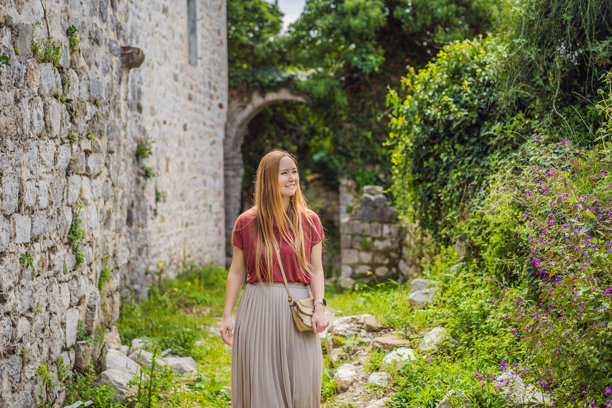 一名女游客走过黑山的巴尔老城。快乐的游客在山上散步。巴尔市郊区，黑山，巴尔干半岛。美丽的自然景观图片下载