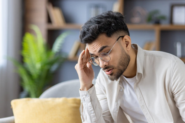 在家头痛的年轻印度男人特写照片图片下载