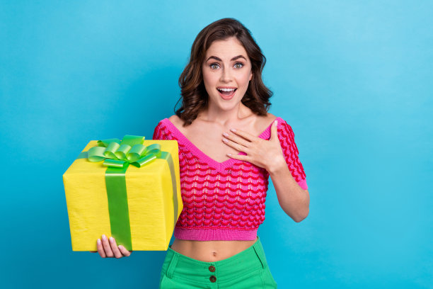 照片上的女士穿着粉色时髦的衣服，给自己留下了深刻的印象，蓝色的背景上是昂贵的礼物图片下载