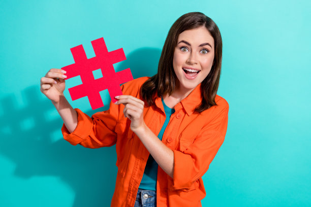 一张穿着橙色时髦衣服的快乐漂亮女士的照片，拿着标签分享帖子转发，在青色背景上孤立图片下载