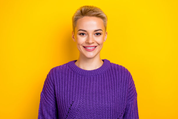 肖像照片喜气洋洋的微笑满意的好心情金发短发女孩穿紫色毛衣看你宣传孤立在黄色的背景图片下载