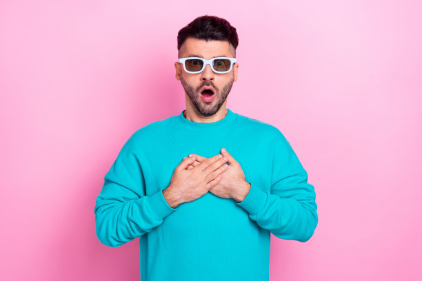 照片的年轻观众有趣的震惊压力家伙穿蓝色毛衣摸胸部看恐怖电影戴3d眼镜孤立的粉红色背景图片下载