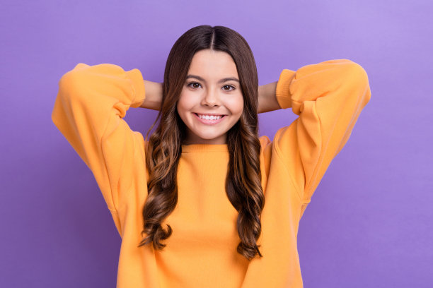 可爱的积极的女士穿着时尚的衣服，抱着手臂在头后梦想暑假孤立的紫色背景的照片图片下载