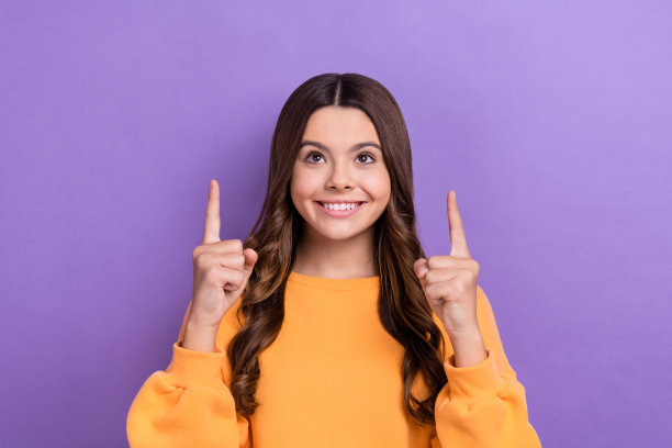 照片正面可爱的女士穿着冬季时髦的橙色毛衣两臂直接空的空间折扣孤立在紫色的背景图片下载