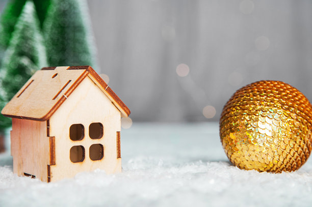 圣诞快乐，新年祝福。以圣诞树球为背景的微型房子模型。图片下载