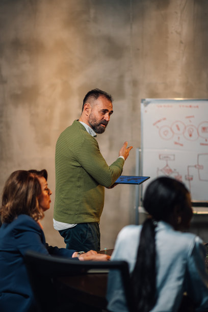 成熟的商人在白板上展示一个新项目的计划图片下载