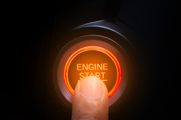 驾驶员的手正在按汽车启动按钮。交通和技术的概念图片下载