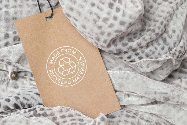 近距离的服装标签与回收图标。回收产品的概念。零浪费，可持续生产，环保和再利用理念。图片下载