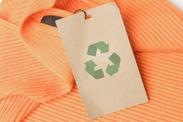 近距离的服装标签与回收图标。回收产品的概念。零浪费，可持续生产，环保和再利用理念。图片下载