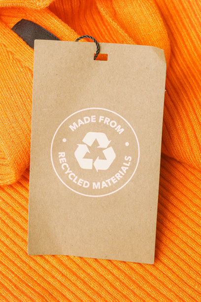 近距离的服装标签与回收图标。回收产品的概念。零浪费，可持续生产，环保和再利用理念。图片下载