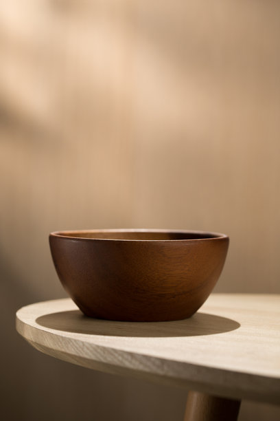 一张竖着的照片，一个日式木碗放在木桌上，上面空着文字，用于广告目的。图片下载