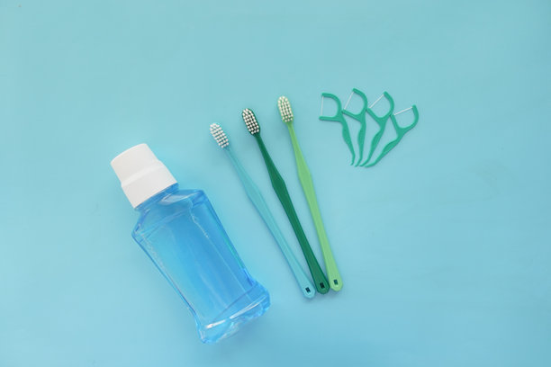 漱口水、牙刷和牙线以蓝色为背景图片下载