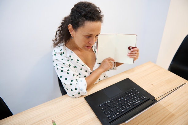 穿着圆点衬衫的女士正在开在线会议，展示笔记本对笔记本，远程工作的概念图片下载