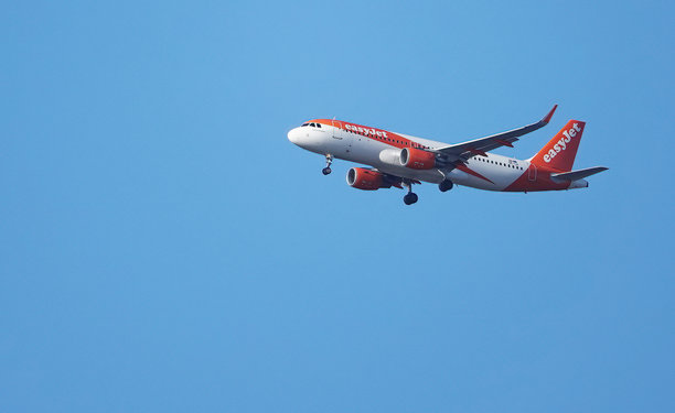 一架易捷航空空客A320客机在晴朗的蓝天上飞行，起落架放下，降落在英国埃塞克斯的绍森德机场。图片下载