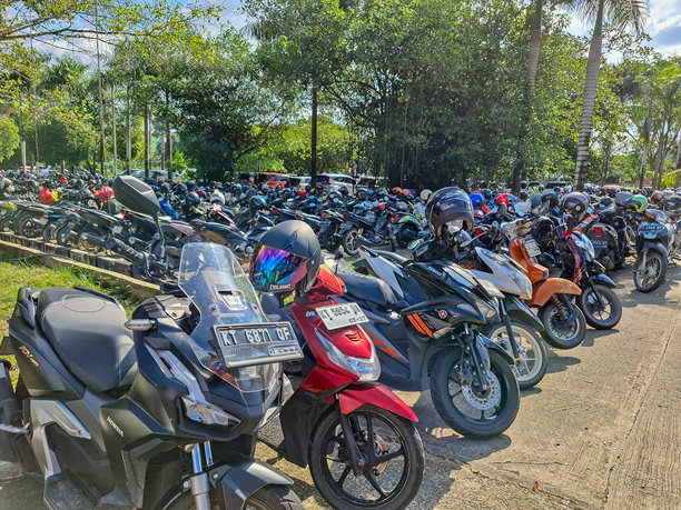开放区域供各种品牌和类型的摩托车停车，没有使用防晒设施。印度尼西亚东加里曼丹邦唐，2024年9月10日。图片下载