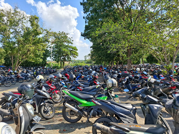 开放区域供各种品牌和类型的摩托车停车，没有使用遮阳设施。印度尼西亚东加里曼丹邦唐，2024年9月10日。图片下载