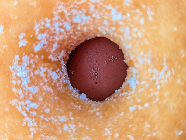 红色背景上的甜甜圈或甜甜圈孔的细节图片下载