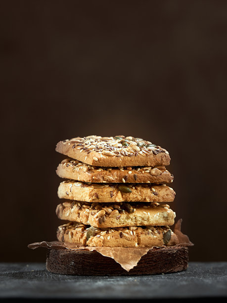 方形巧克力饼干撒上糖粉，背景为棕色。照片留有空白空间。图片下载